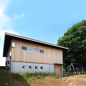 傾斜地に建つ木造平屋の住宅 菜園へ抜ける土間