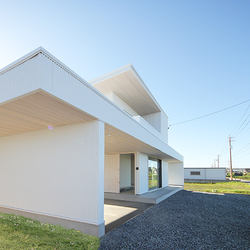 片流れ屋根の白い外壁 車寄せのある土間玄関